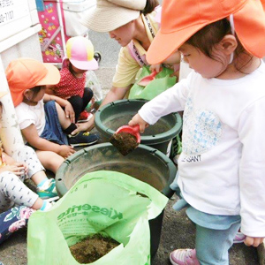 野菜栽培のための土を鉢に入れる子どもたち